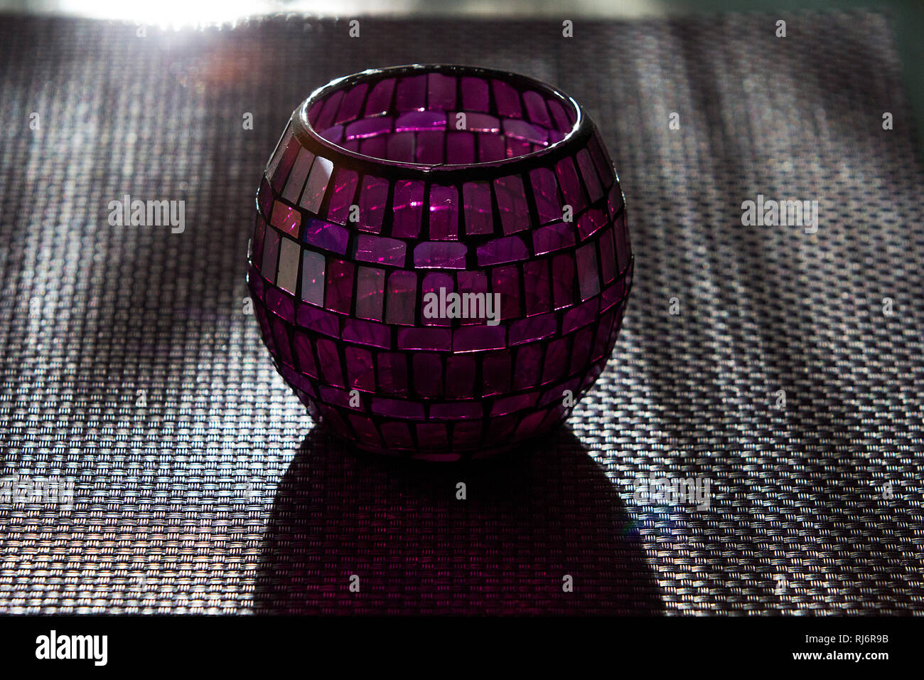 Ball shaped candle holder made of tiny color glasses in ambient