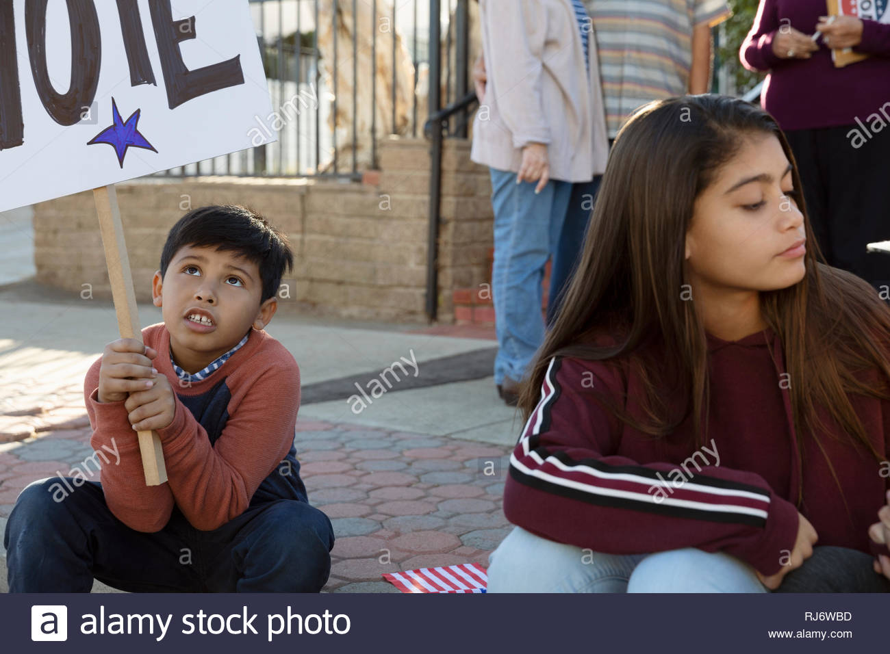 Latinx boy and girl volunteering, canvassing voters Stock Photo