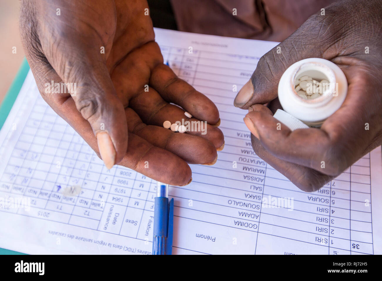 Bodadiougou village, Banfora, Cascades Region, Burkina Faso, 4th December 2016; Distribution of Ivermectin. Accurate record keeping is essential. This is part of the programme  to prevent River Blindness in the region. Stock Photo