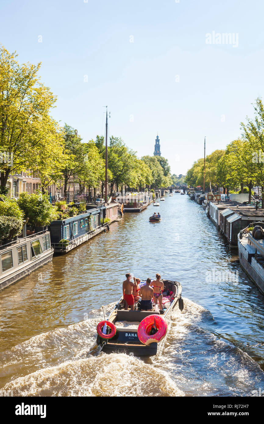 Niederlande, Amsterdam, Prinsengracht, Hausboote, junge Menschen auf Motorboot Stock Photo
