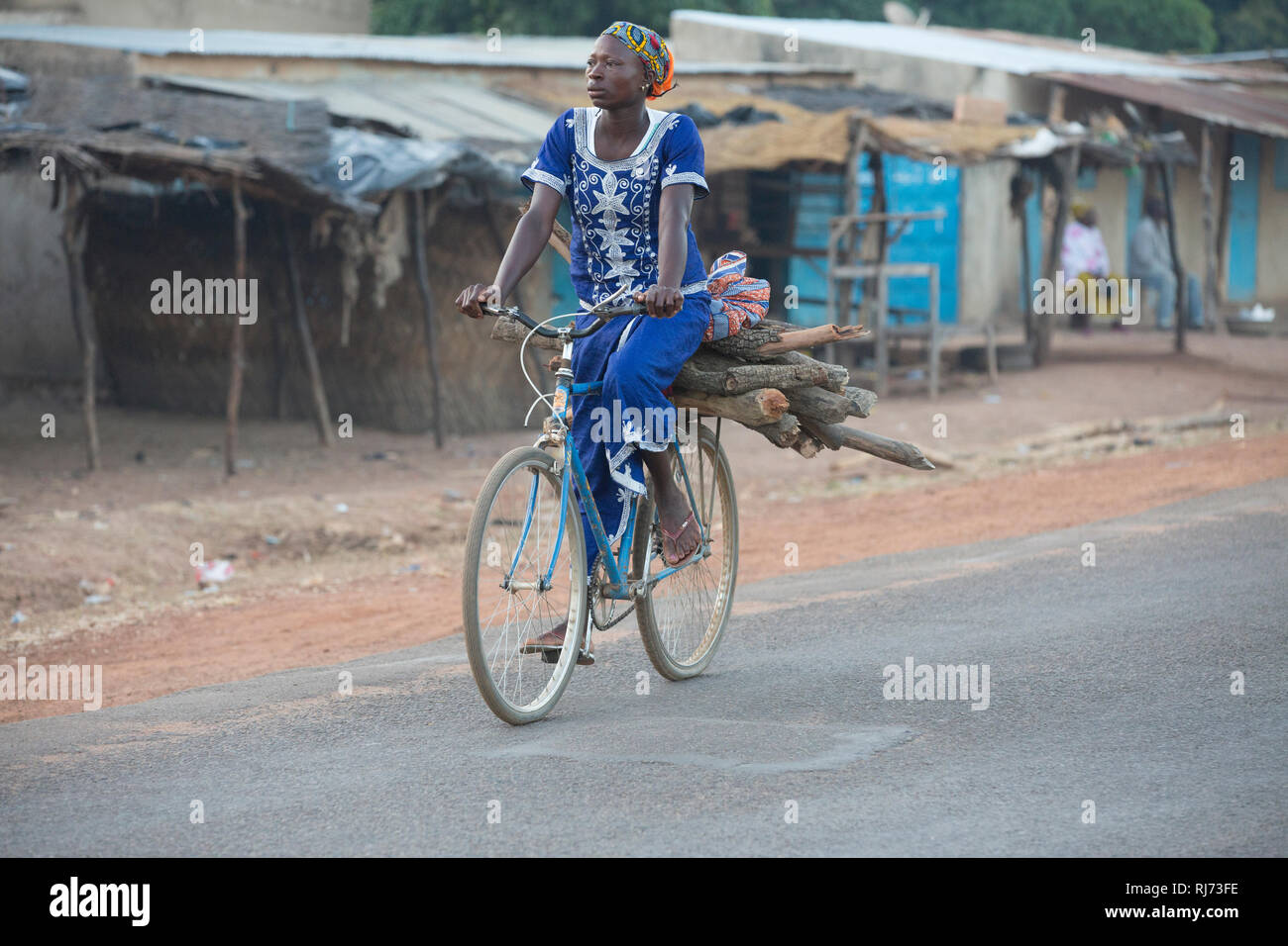 Diarabakoko village, Banfora, Cascades Region, Burkina Faso, 5th December 2016; A woman carrying firewood on her bike. Stock Photo