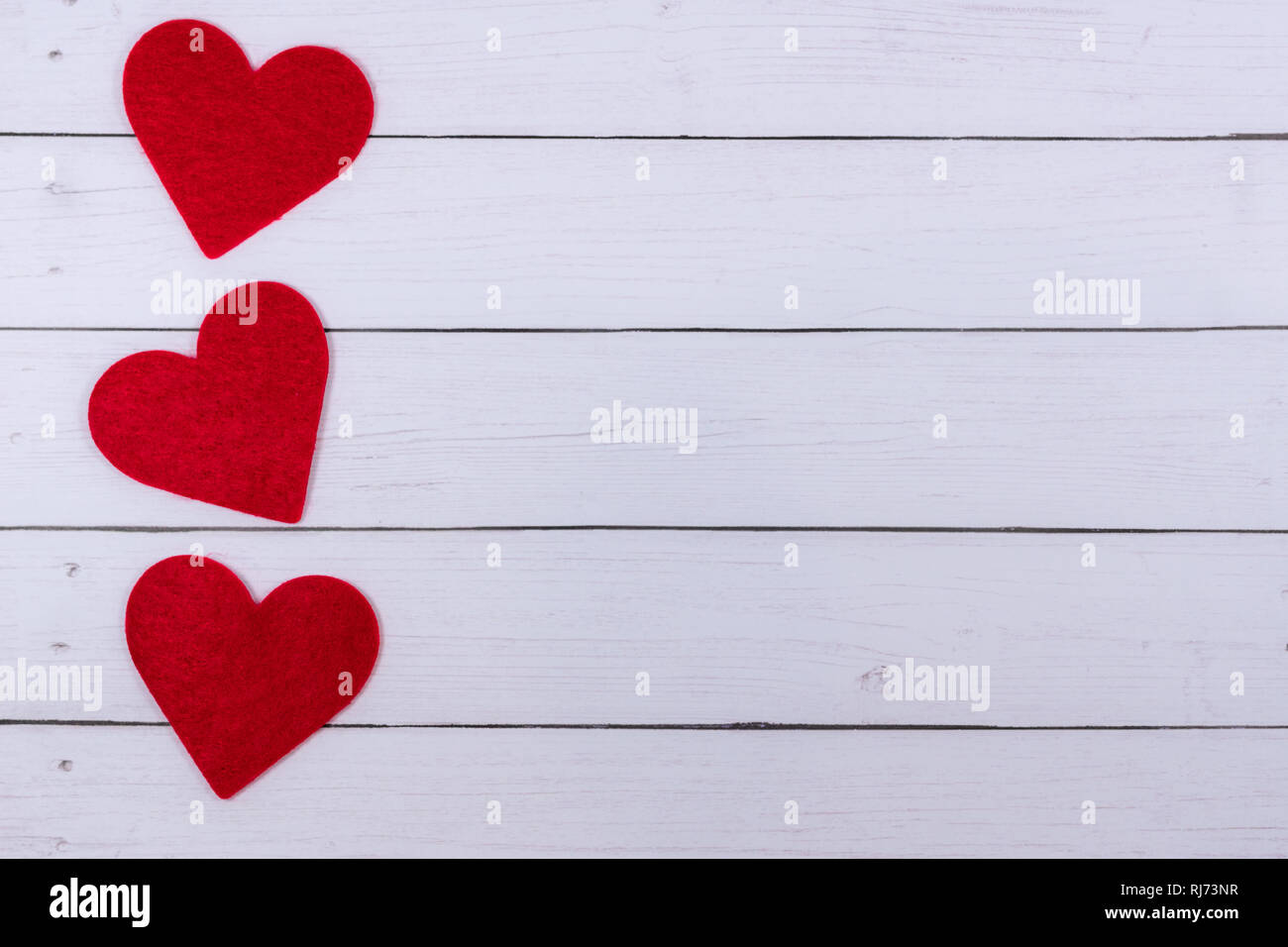 White Saint Valentine's day background with three red hearts on the ...