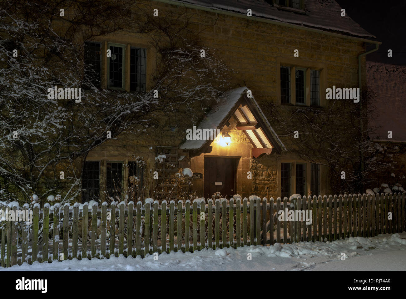Cottage in sherborne street in Bourton on the Water in the early morning snow before dawn. Bourton on the Water, Cotswolds, Gloucestershire, England Stock Photo