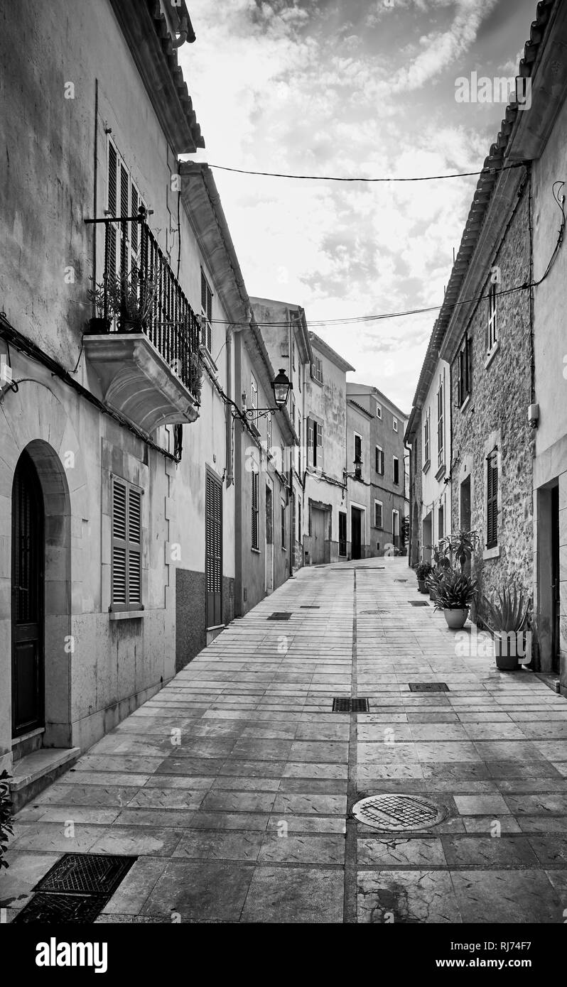 Black and white picture of a narrow steep street in Alcudia old town, Mallorca, Spain. Stock Photo