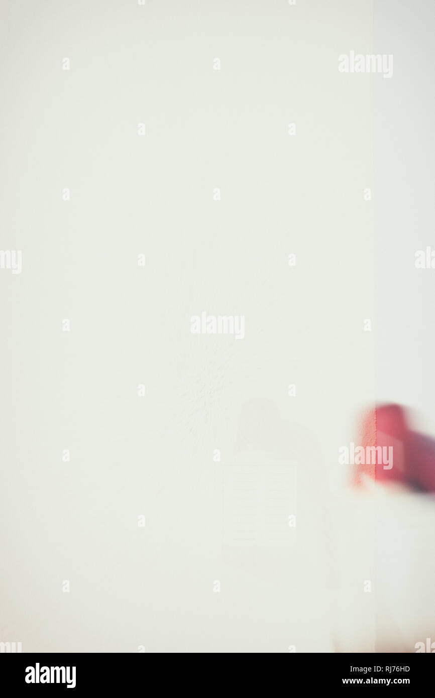 Eine verwackelte rote Warnleuchte mit Lautsprecher wirft Schatten an einer weißen Wand, Stock Photo