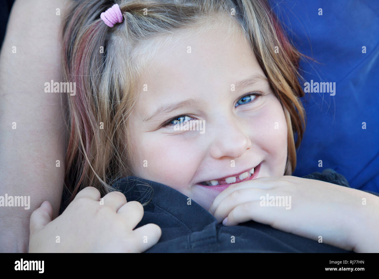 Portrait eines achtjähriges Mädchen in den Armen ihrer Mutter Stock Photo