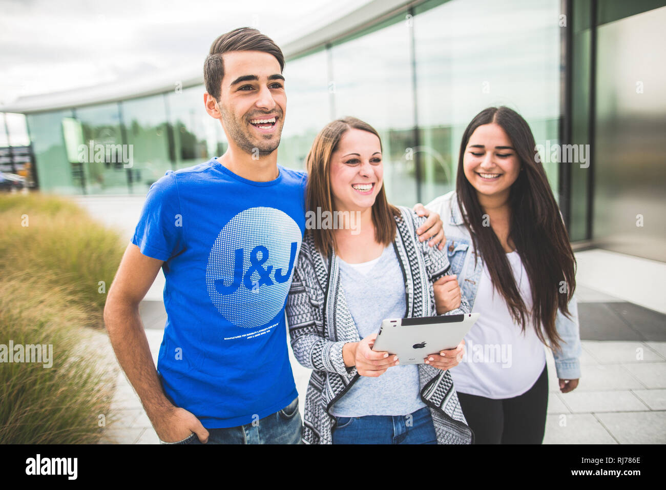 Drei Jugendliche mit Tablet unterwegs Stock Photo