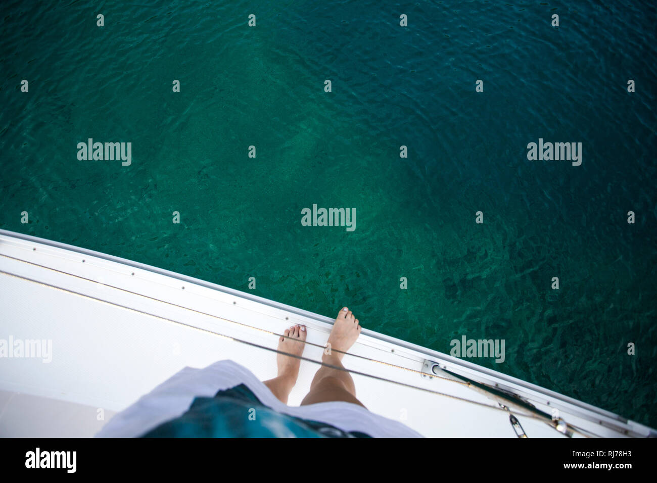 Blick vom Segelboot über Füße ins Meer Stock Photo