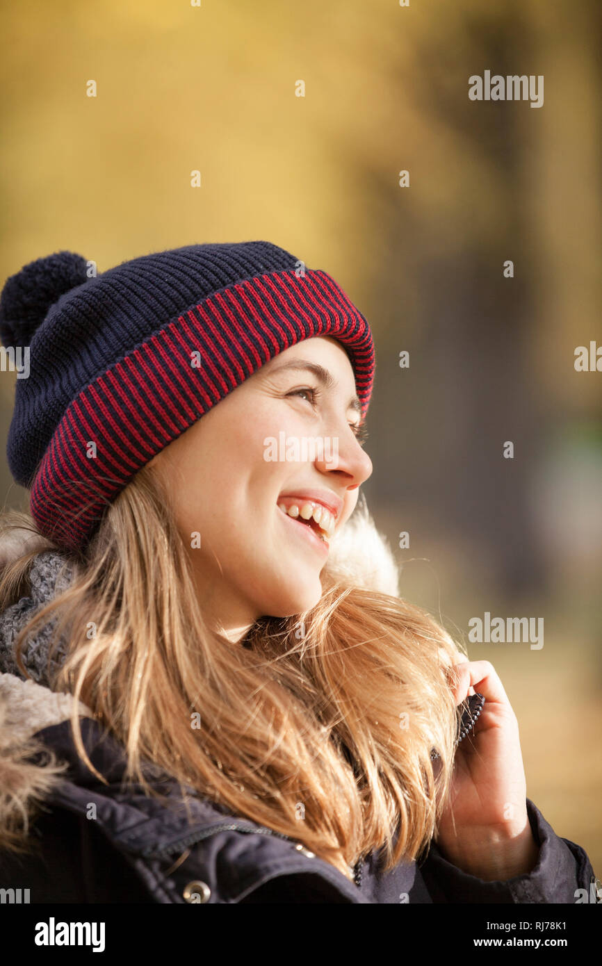 Frau im herbstlichen Park lächelt zur Seite Stock Photo