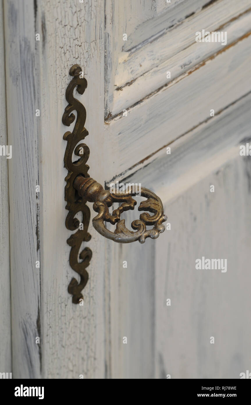 Möbelbeschlag in Altmessing, kunstvoll verschnörkelt, antiker Schlüssel Stock Photo
