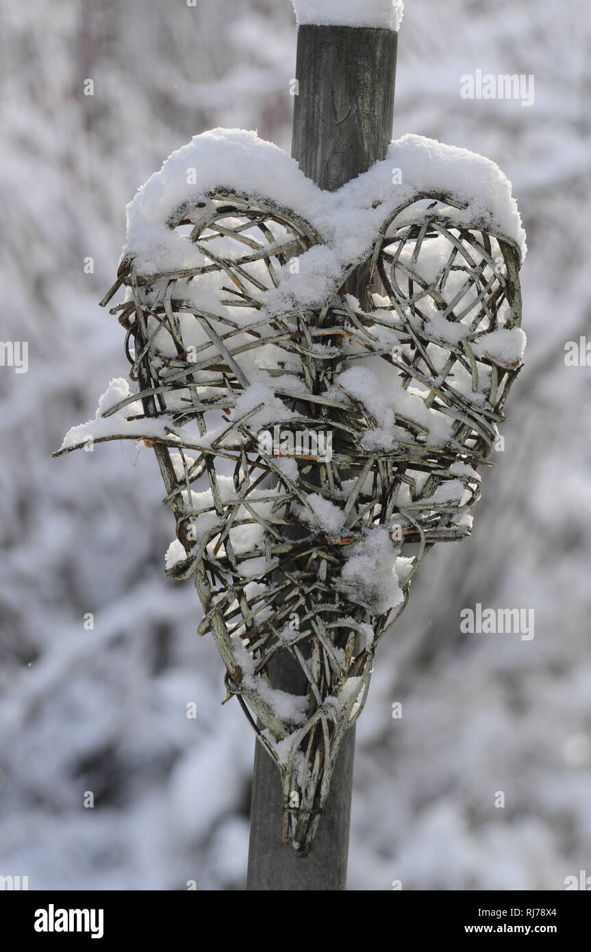 Aus Zweigen geflochtenes Herz mit Schnee bedeckt, close-up Stock Photo