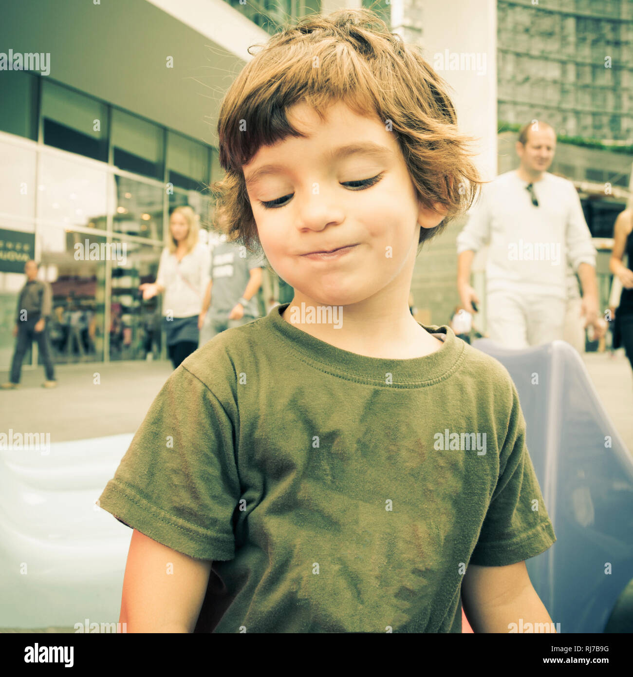 Child with green sweater in the center of Milan in the autumn Stock Photo