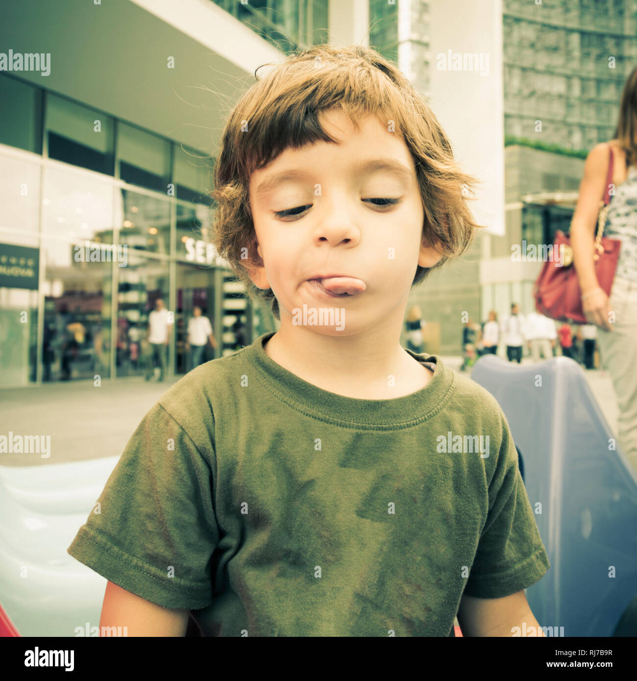 Child with green sweater in the center of Milan in the autumn Stock Photo