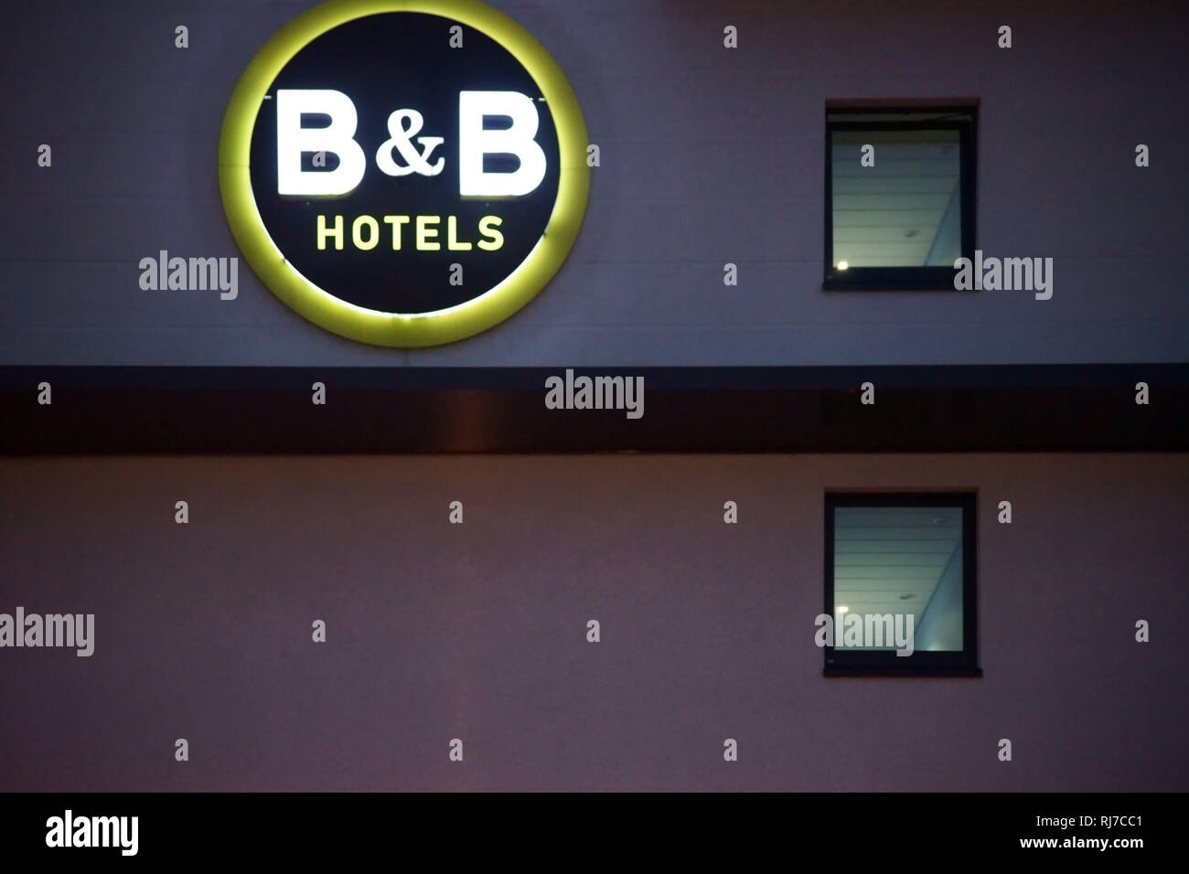 Die Fassade eines neonbeleuchteten B & B Hotels mit Neonröhren und Logo am Abend in Darmstadt. Stock Photo