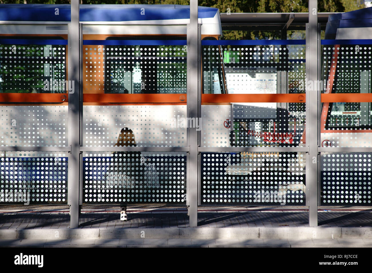 Der neue gebaute Glasunterstand einer modernen Straßenbahnhaltestelle an einer Straße. Stock Photo