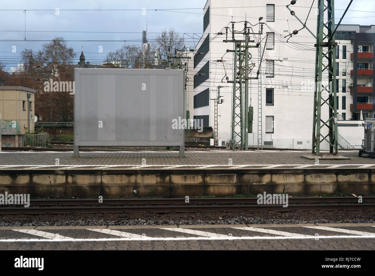 Eine leere Plakatwand und Werbefläche steht auf einem Bahnsteig an den Gleisen. Stock Photo