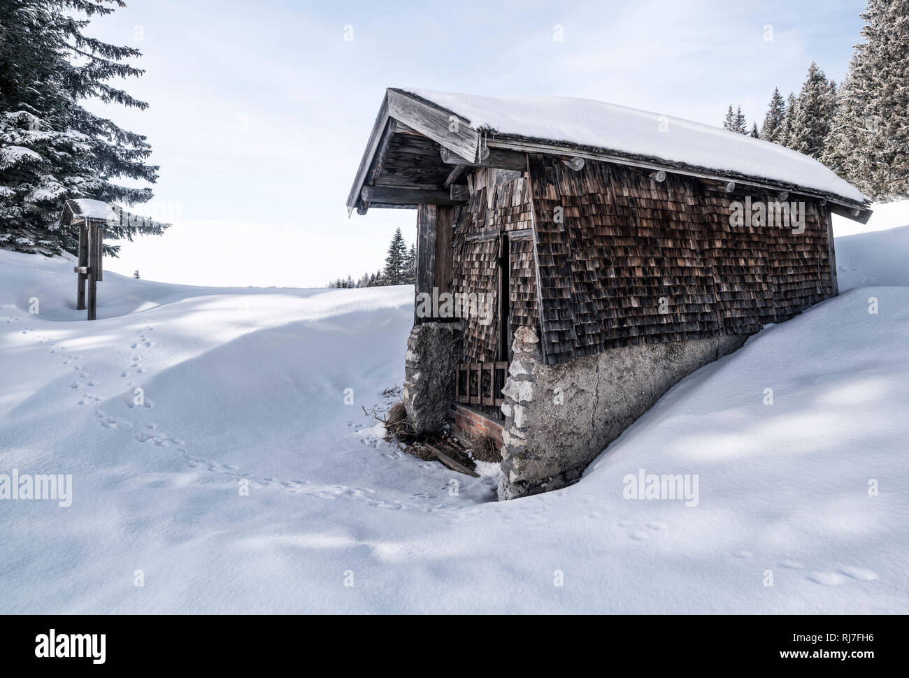 Kleine Hütte mit Holzschindeln im Winter am Tegelberg in Süddeutschland, Stock Photo