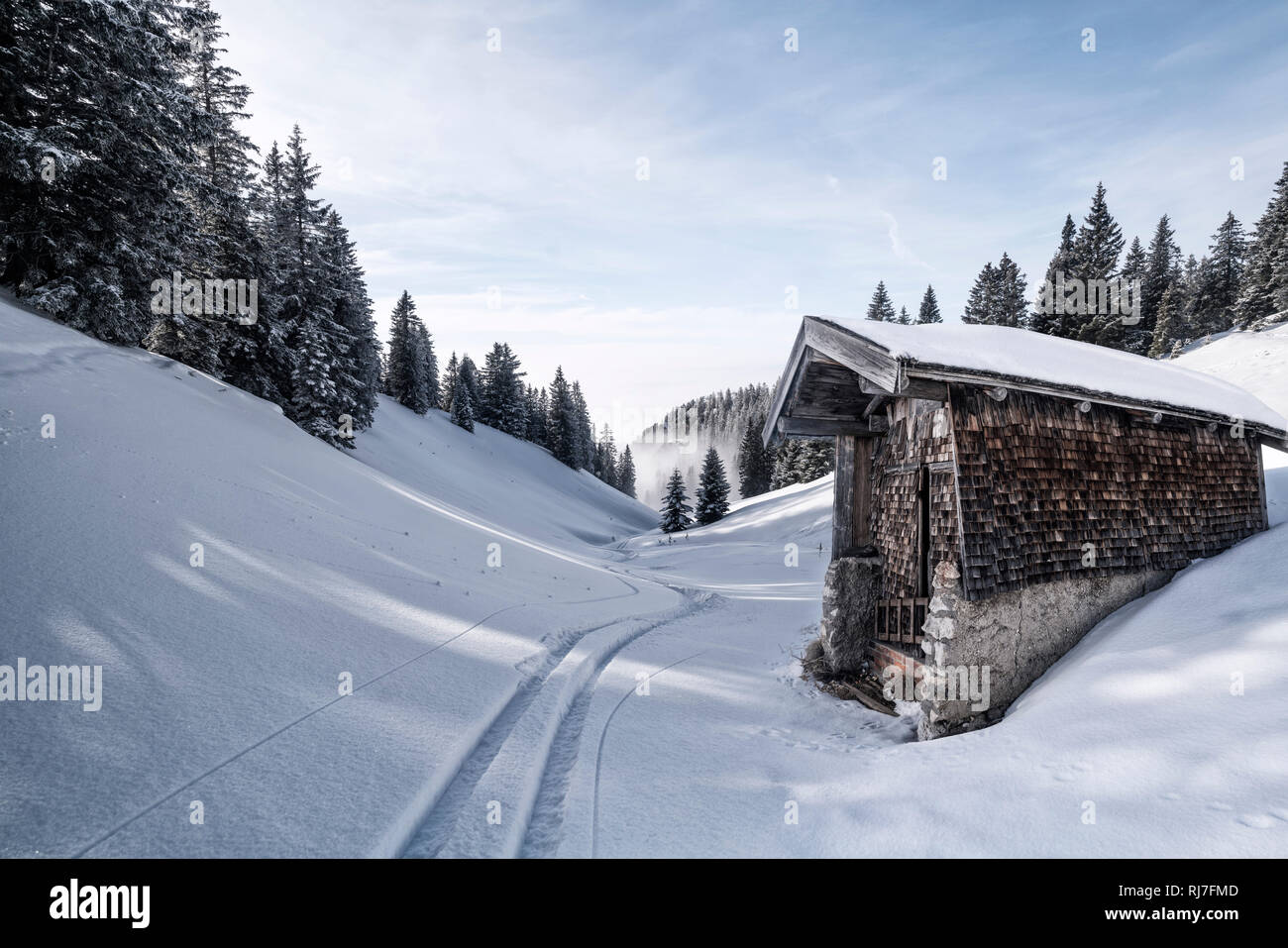 Skispur vor kleiner Hütte mit Holzschindeln im Winter am Tegelberg in Süddeutschland, Stock Photo