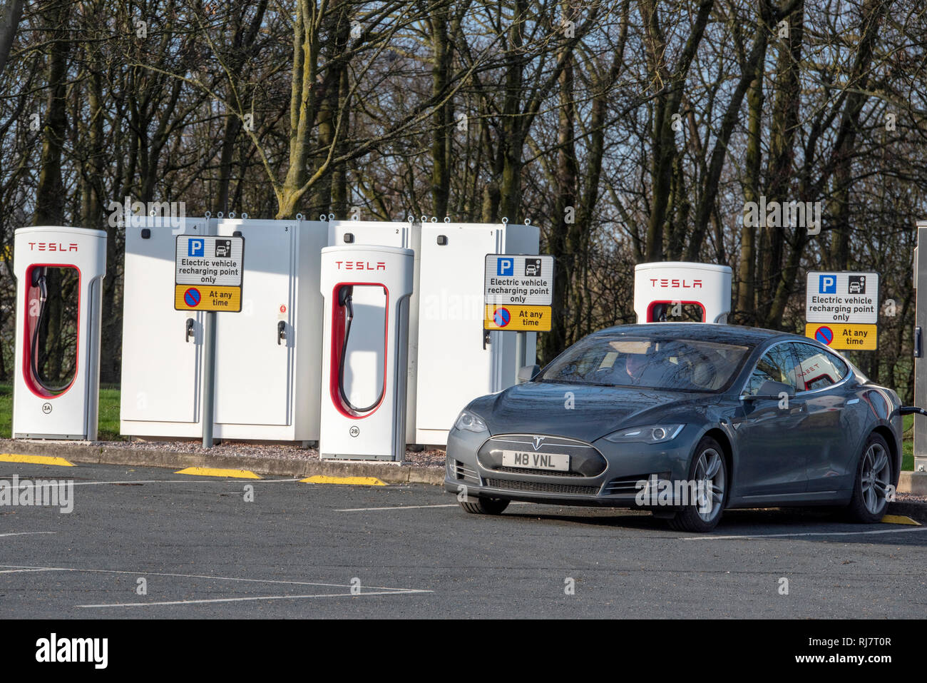 Tesla electric car charging at a charging station at Burtonwood services on the M62. Stock Photo