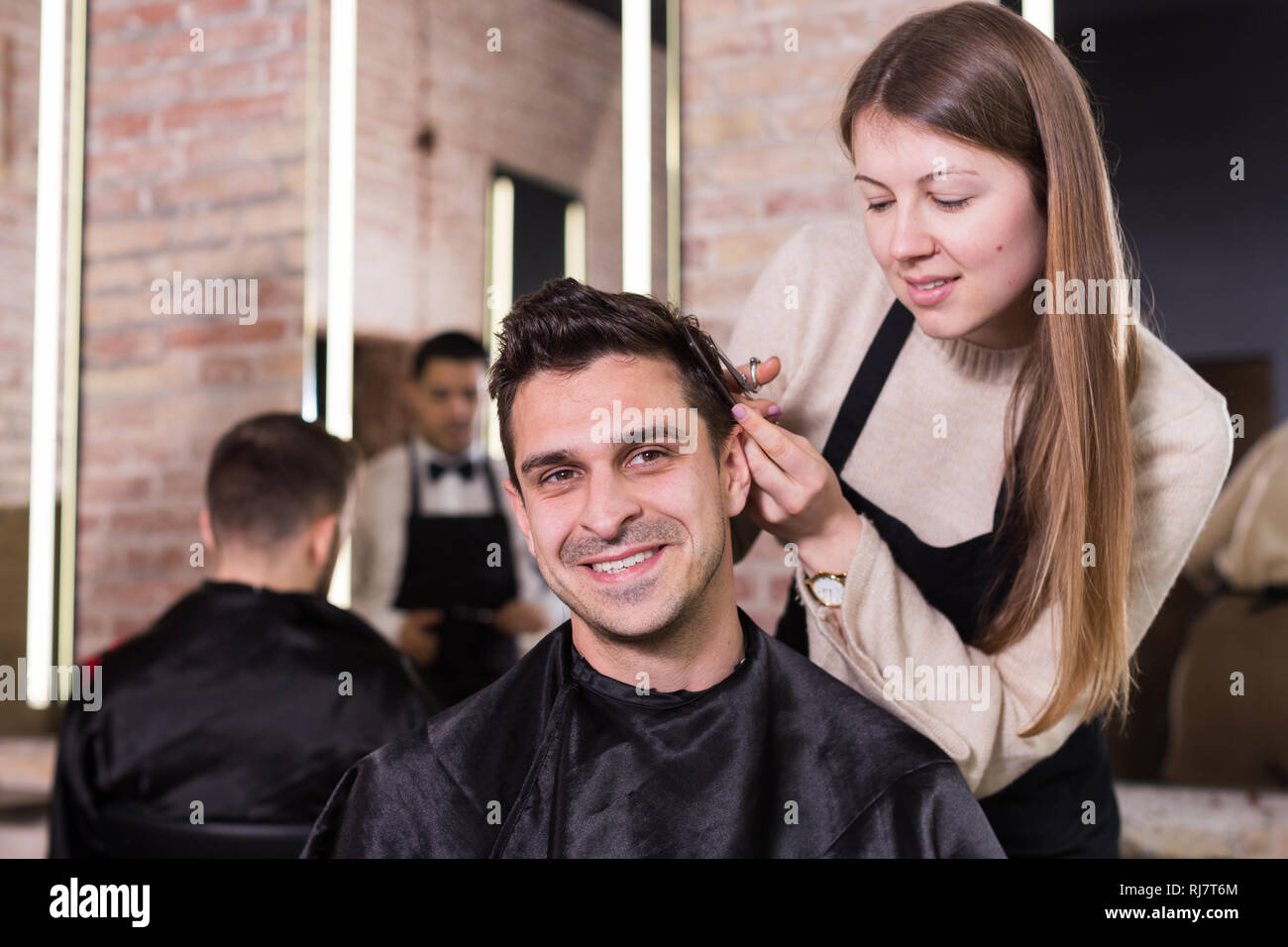 Handsome Male Client Getting Haircut By Professional Hairdresser