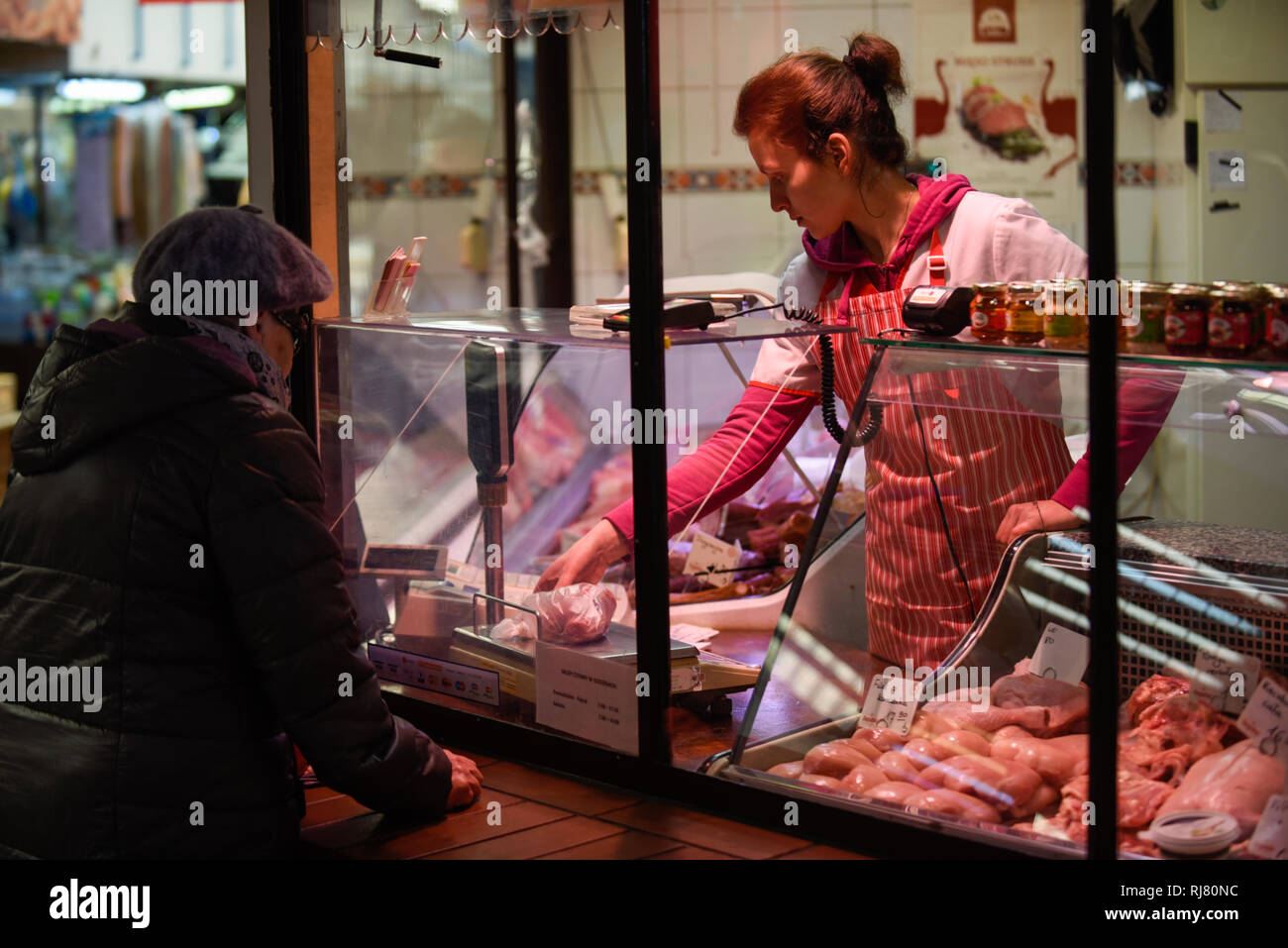 A woman seems buying pieces of meat at a meat market. European Union investigators began a weeklong visit to Poland on Monday after a video showing sick cows being illegally slaughtered during night at a slaughterhouse in the northeastern Polish town of Ostrow Mazowiecka . The meat from the abattoir went to Estonia, Finland, France, Hungary, Lithuania, Portugal, Romania, Spain, and Sweden. European Union investigators began a weeklong visit to Poland on Monday for inspections. Stock Photo
