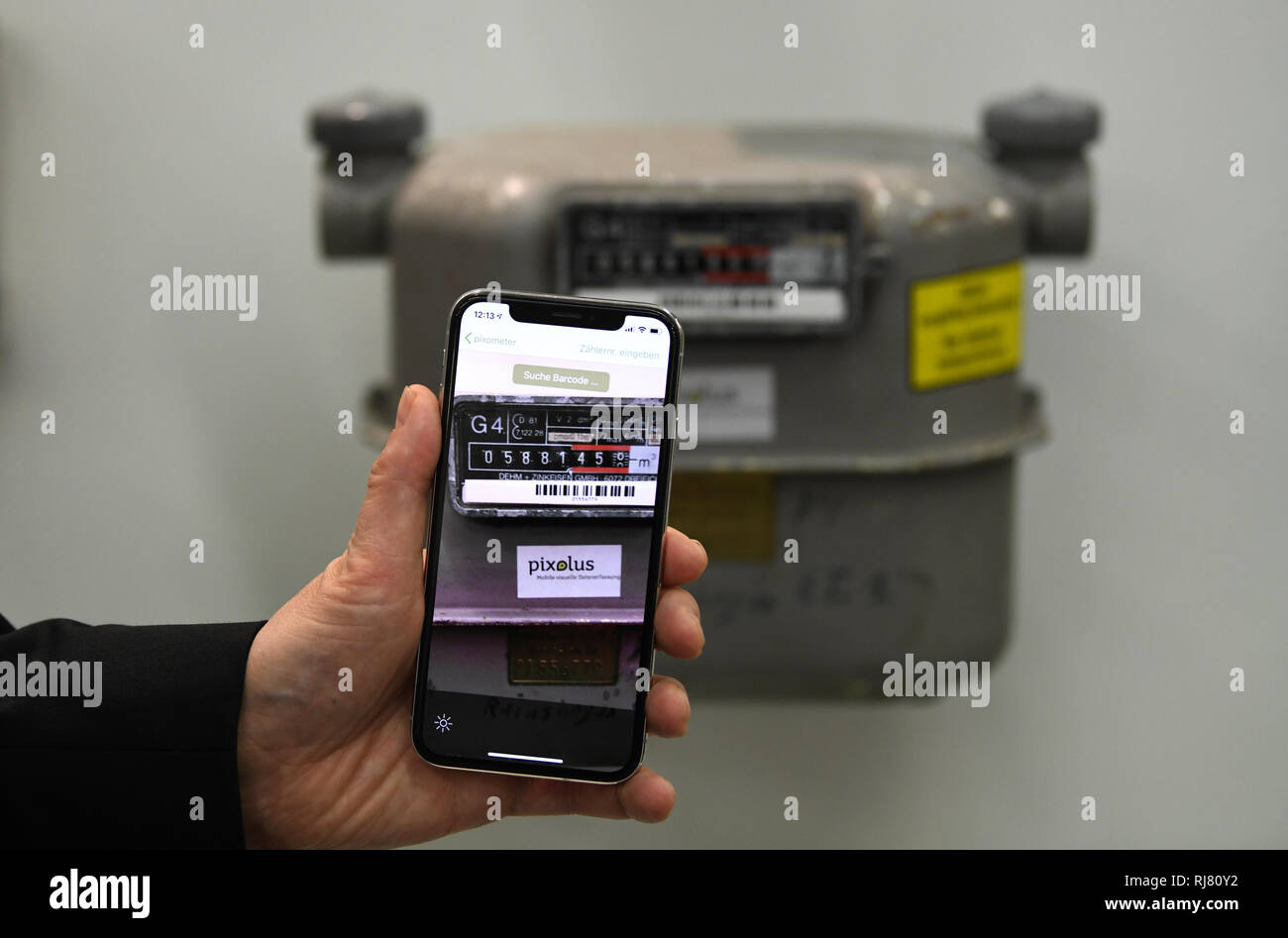 Essen, Germany. 05th Feb, 2019. An employee scans a meter reading of a gas  meter with his mobile phone at a pixolus booth at the trade fair "E-world  energy & water". From