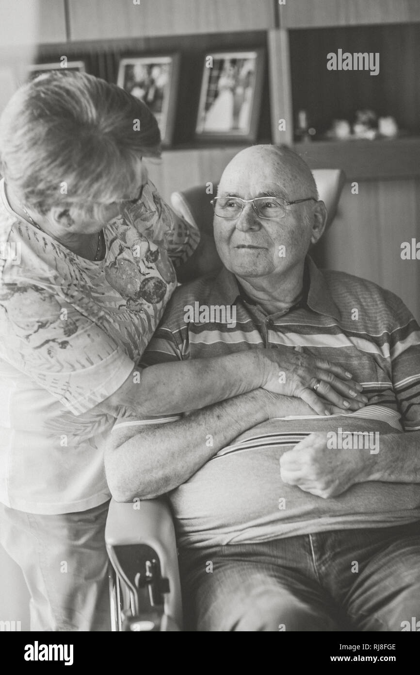 Glückliches Seniorenpaar Zuhause, Mann im Rollstuhl, s/w Stock Photo