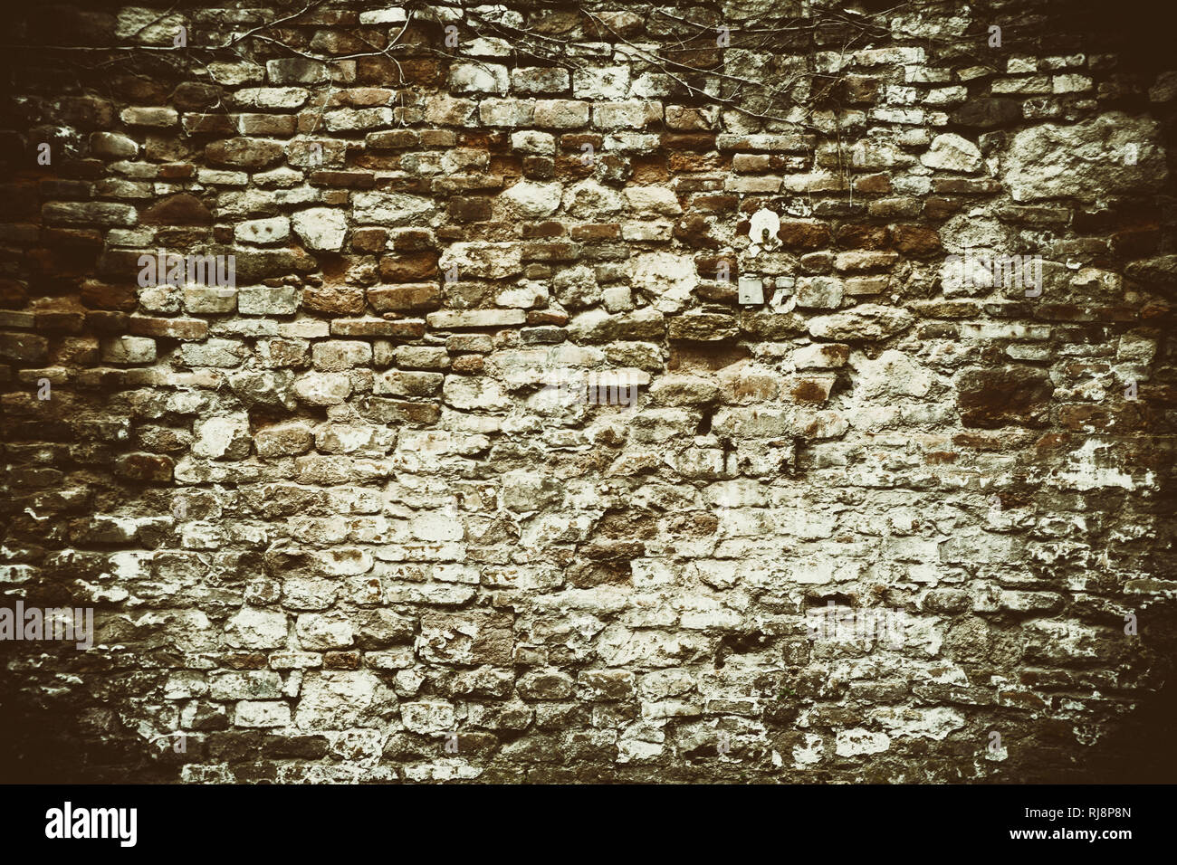 Rustikale Mauer aus versetzten und abgebrochenen Ziegelsteinen Stock Photo