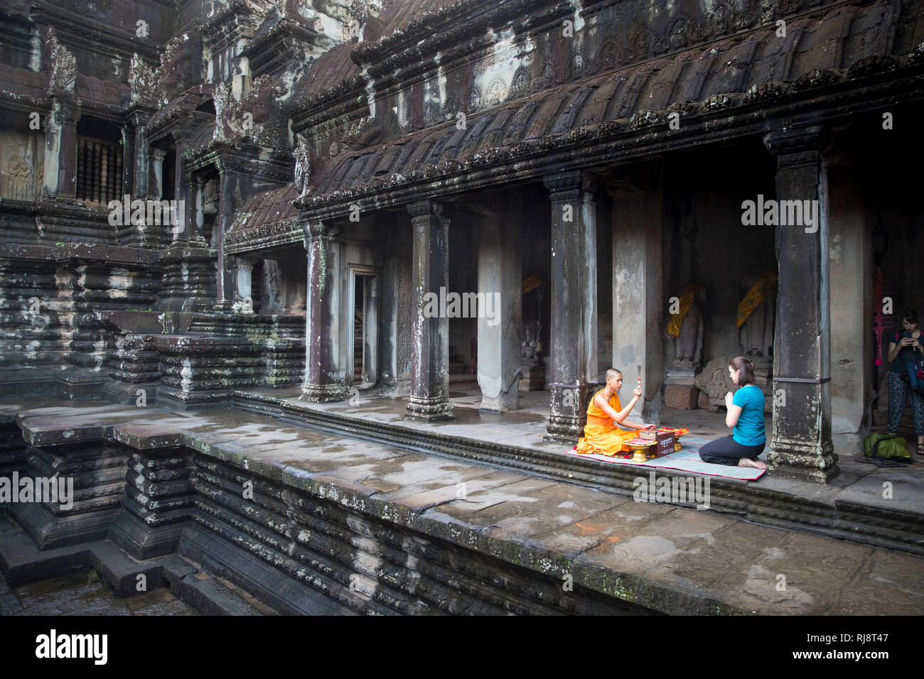 Siem Reap, Angkor, Angkor Wat Tempel, ein Mönch spricht für einen Dollar ein Gebet für eine Touristin Stock Photo