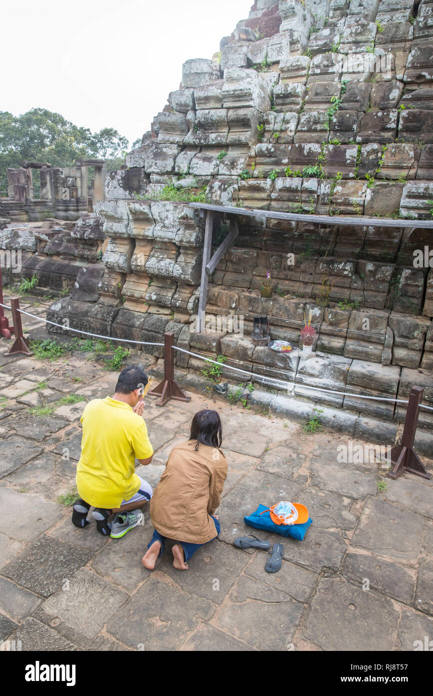 Siem Reap, Angkor, Tempel Baphuon, ein kambodschanisches Paar beim beten auf dem Tempeldach Stock Photo