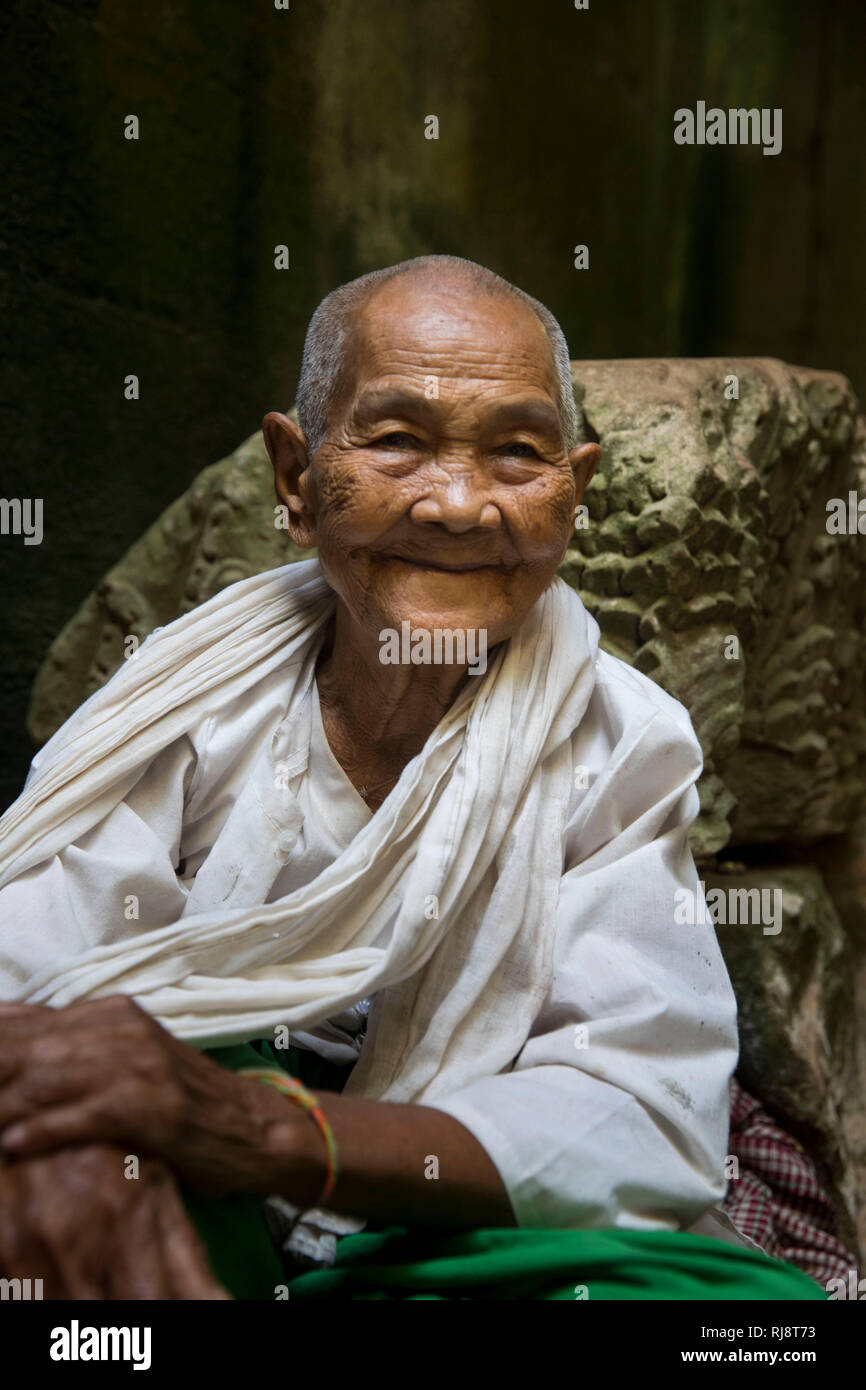 Siem Reap, Angkor, Tempel Preah Khan, alte Dame betet für dich und bindet dir dann ein Band um die Hand Stock Photo