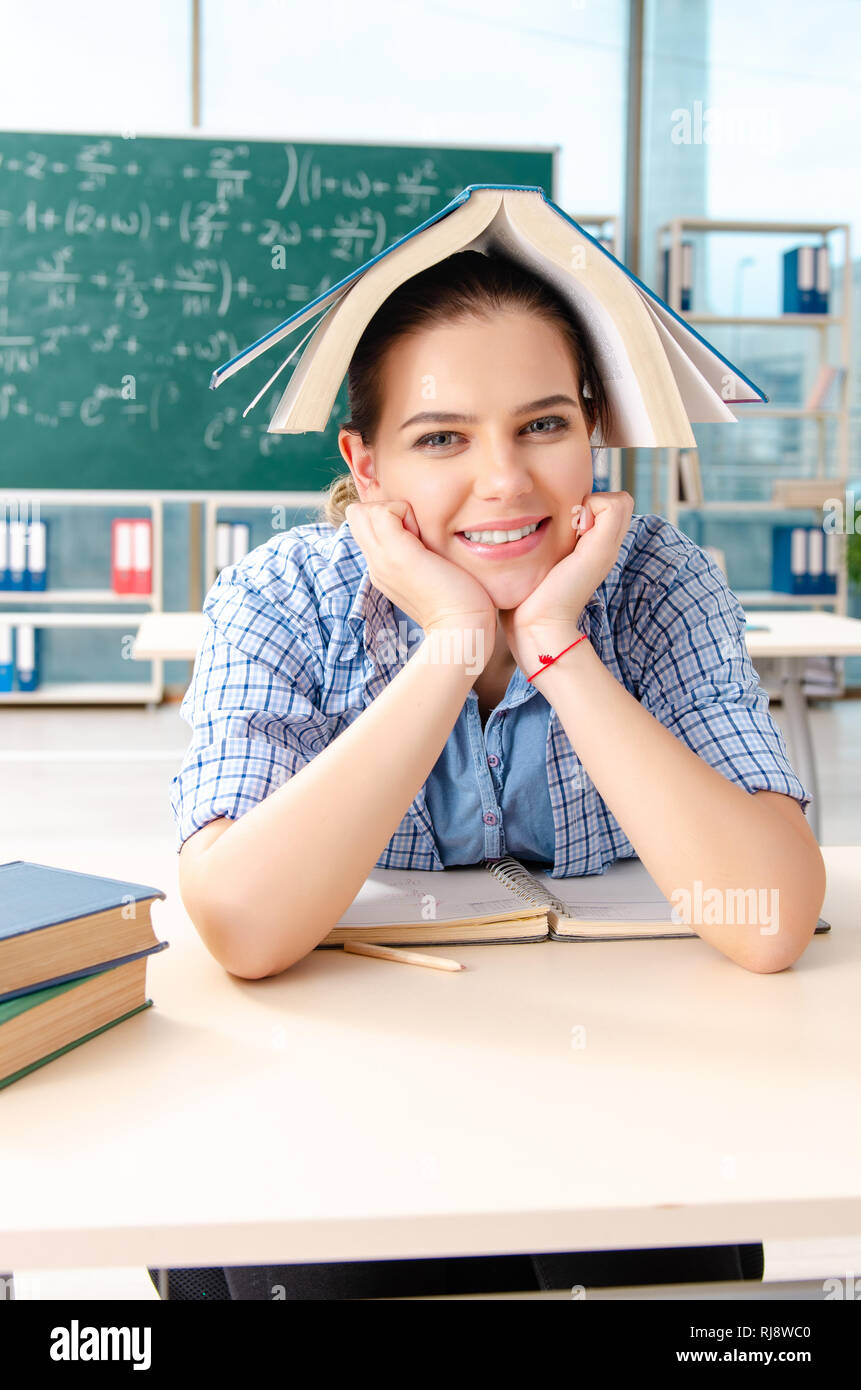 Female student with many books sitting in the classroom Stock Photo - Alamy