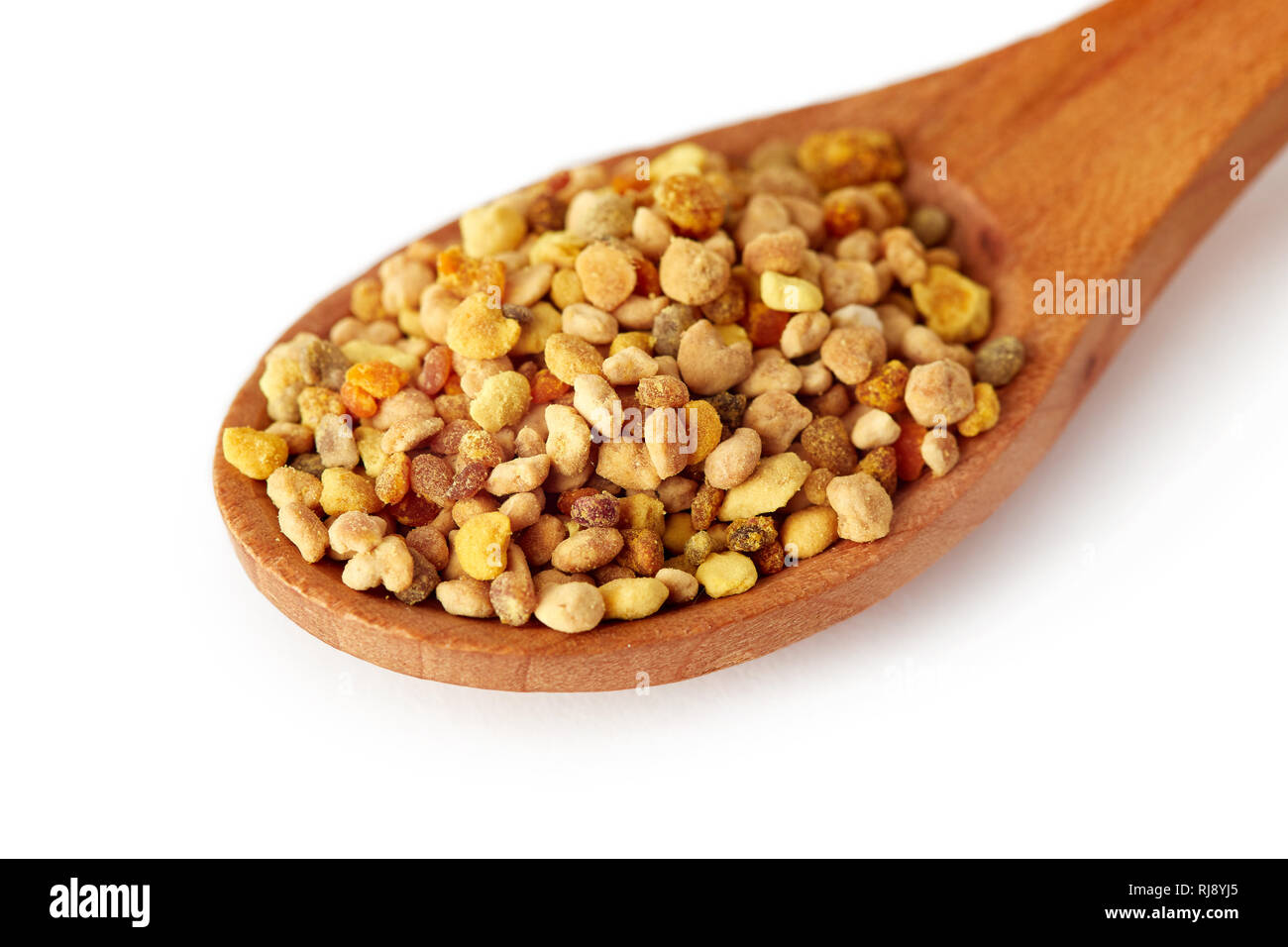 Bee pollen grains in wooden spoon isolated on white background Stock Photo