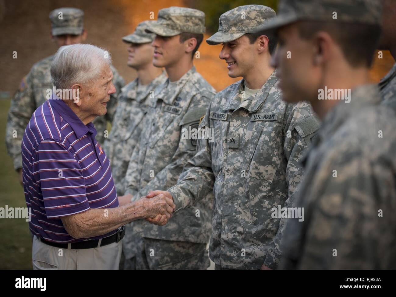Clemson Univeristy professor emeritus, alumnus, and WWII hero Ben Skardon, 99, a survivor of the Bataan Death March, greets ROTC cadets who came to place flags around the Scroll of Honor for Military Appreciation Day, Nov. 3, 2016. Stock Photo
