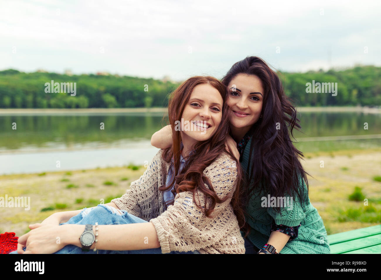 Close up lifestyle portrait of two pretty sisters smiling hugs. Family values concept. Stock Photo