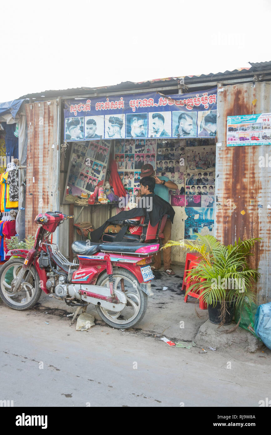 Kambodscha, Phnom Pens, Straßenszene, Frisörladen mit Mofa Stock Photo
