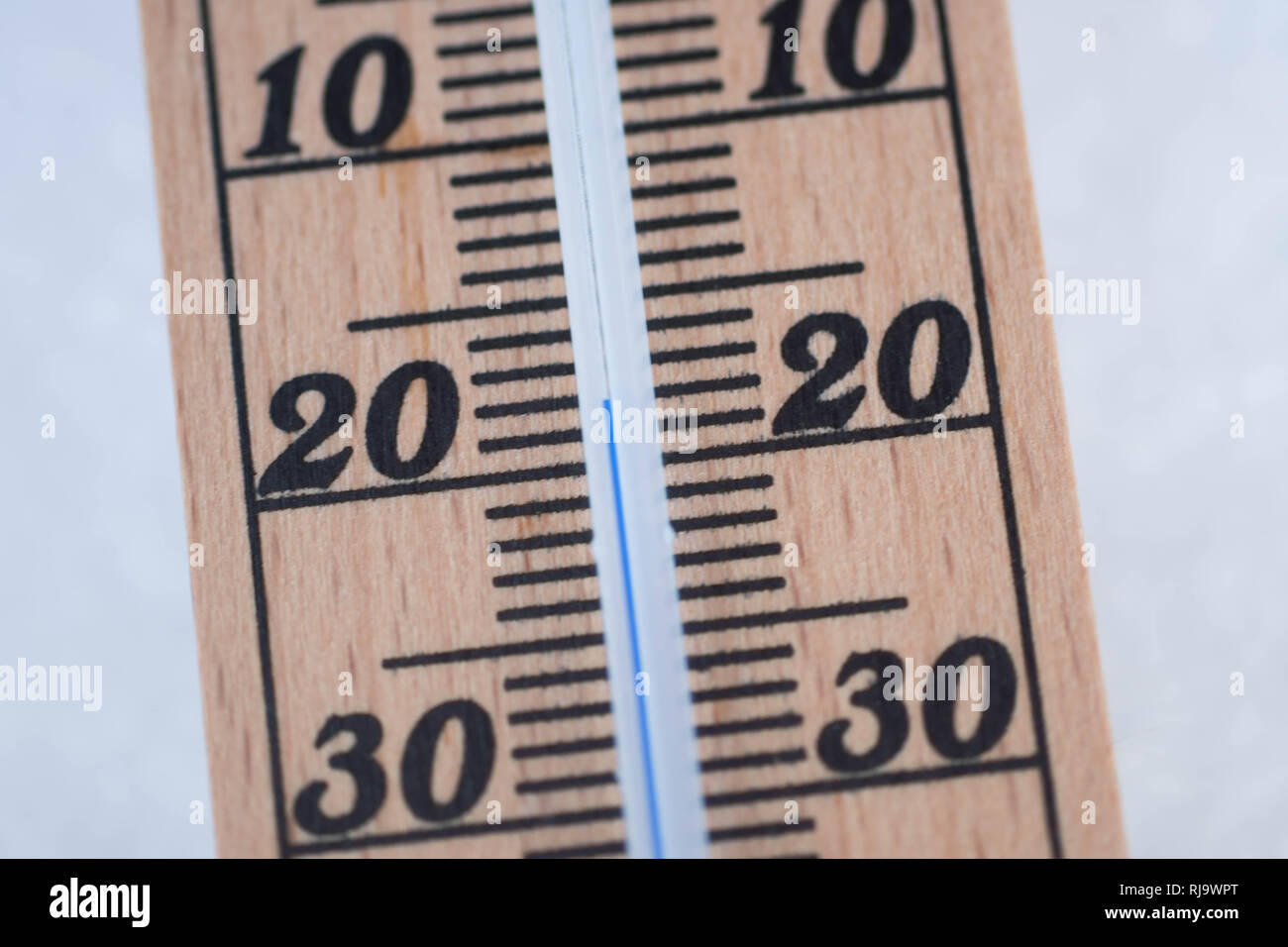 wooden thermometer in snow with freezing temperature Stock Photo