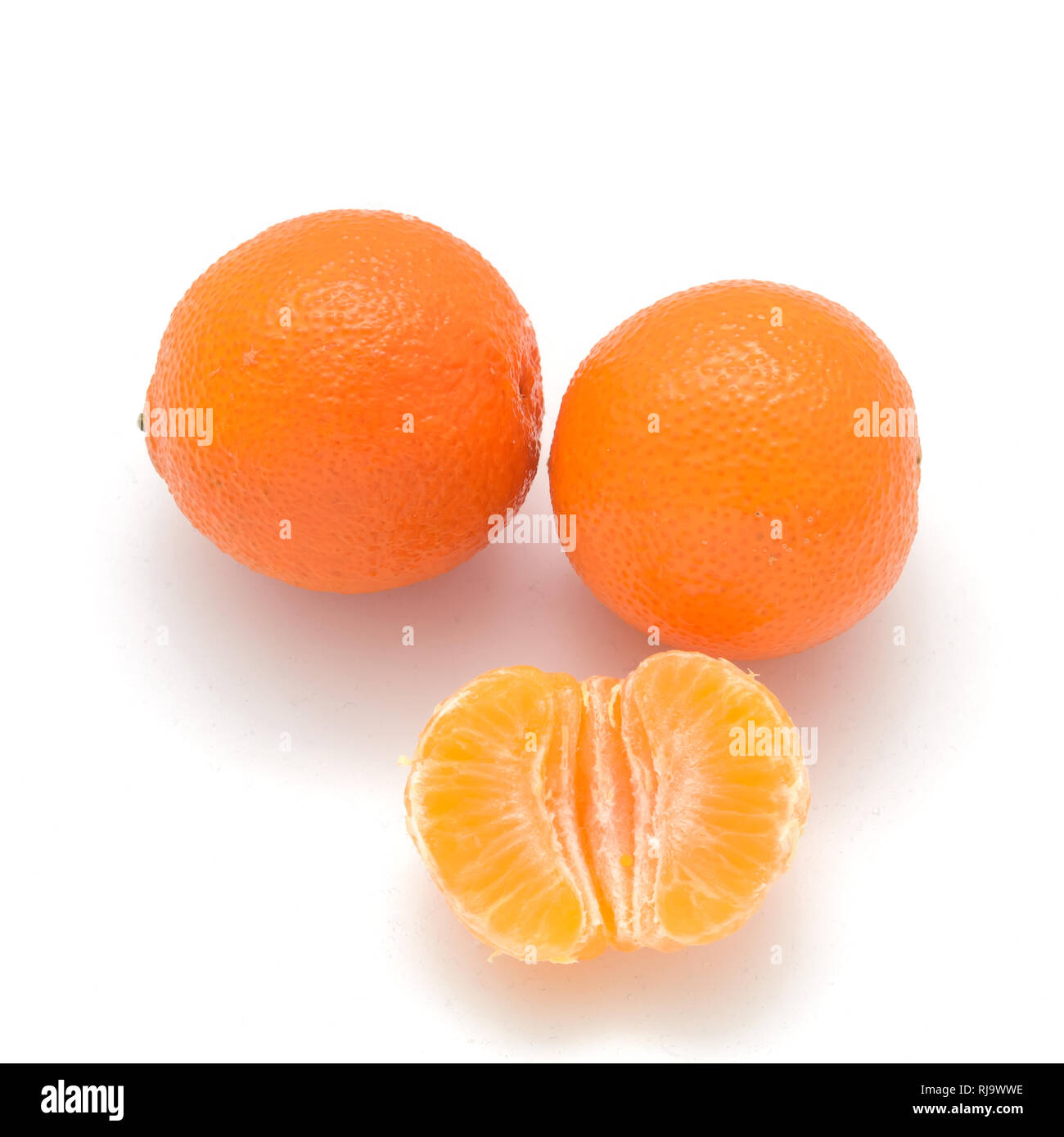 two Mandarin and one half isolated on white background Stock Photo