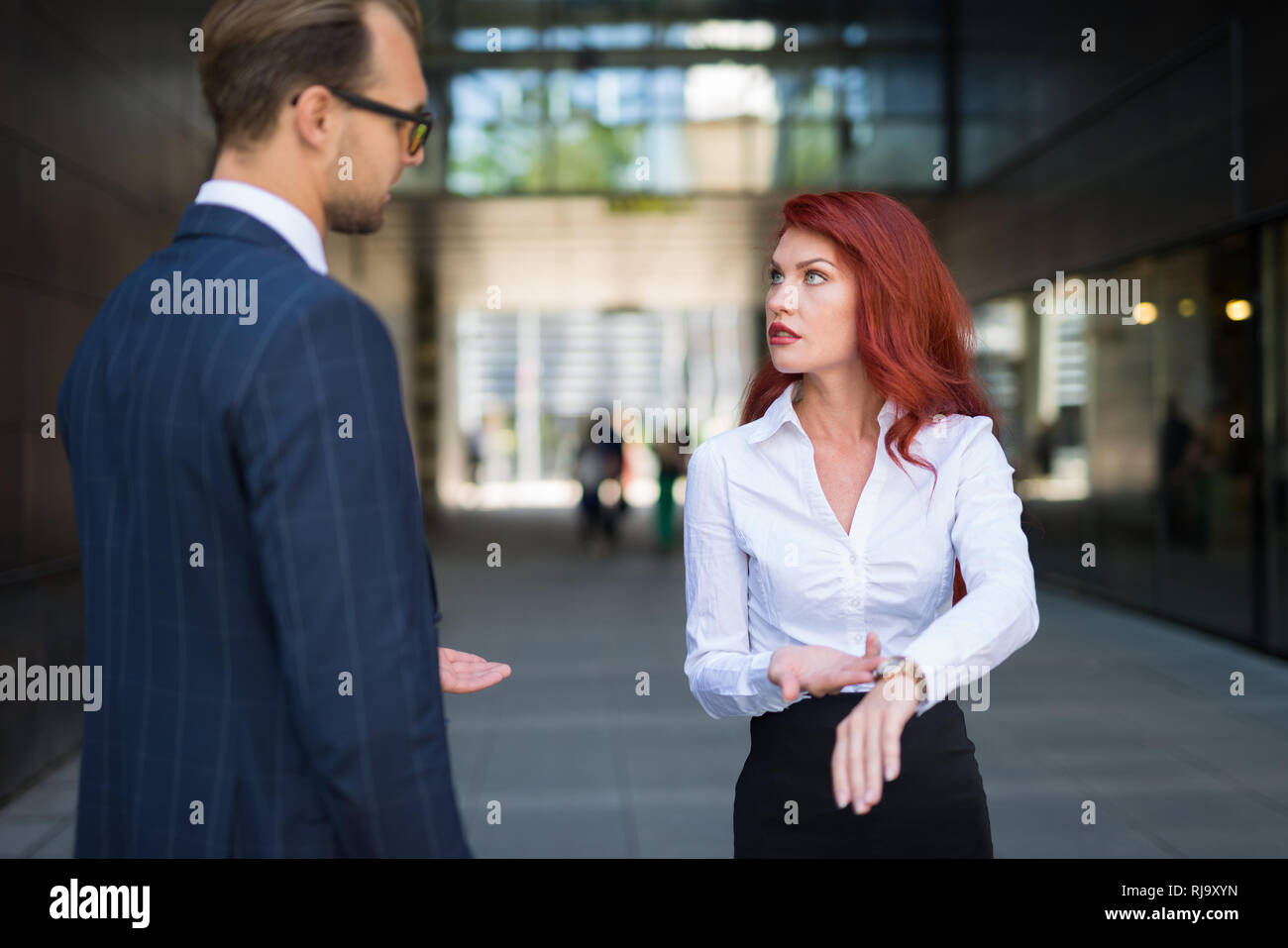 Woman scolding a colleague for being late Stock Photo