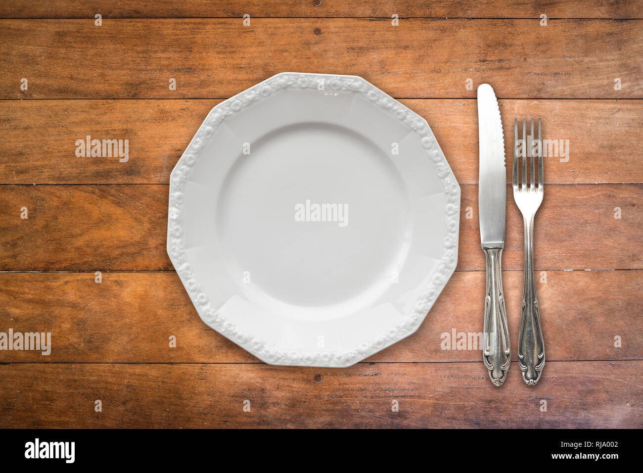 empty plate , fork and knife on wooden table Stock Photo