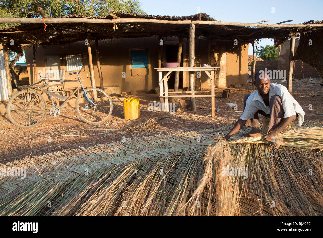 Koassa village, Yako, Burkina Faso, 2nd December 2016; Weaving matting in the early morning. Stock Photo