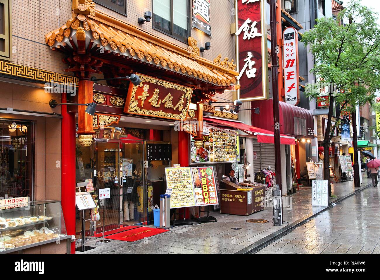 YOKOHAMA, JAPAN - MAY 10: People walk past Chinese restaurant in Chinatown on May 10, 2012 in Yokohama, Japan. Yokohama's Chinatown is the largest in  Stock Photo
