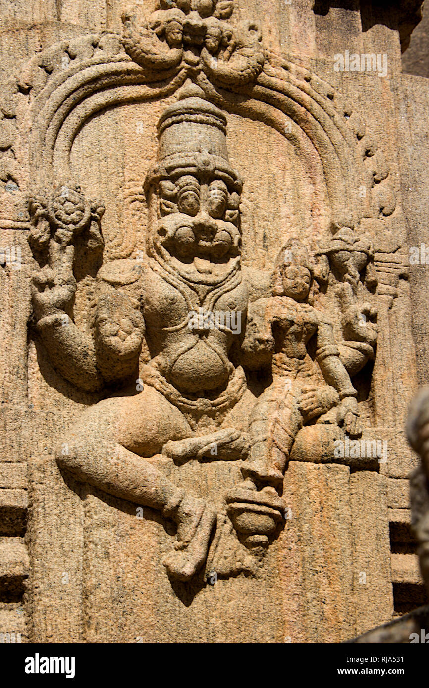 Carving of Narasimha squatting with Lakshmi on his lap on stone pillar ...