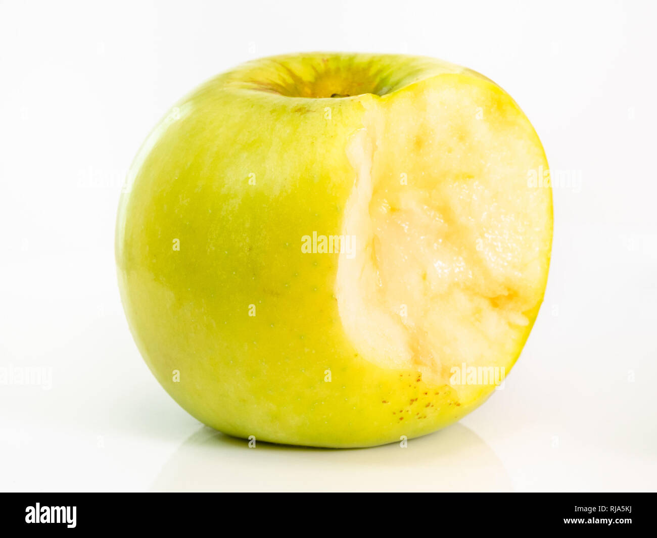 bitten yellow apple fruit on plate on white background Stock Photo