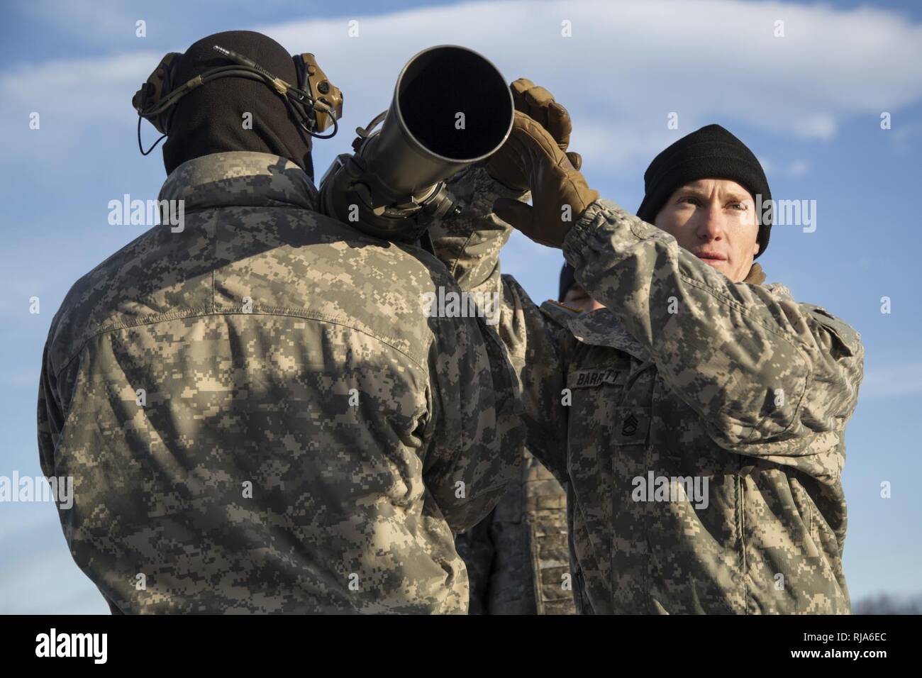 Sergeant 1st Class Robert Barrett, right, a native of Kalispell, Mont., assigned to Baker Company, 3rd Battalion, 509th Parachute Infantry Regiment, 4th Infantry Brigade Combat Team (Airborne) 25th Infantry Division, U.S. Army Alaska, instructs fellow Soldiers how to operate the Carl Gustaf recoilless rifle system at Joint Base Elmendorf-Richardson, Alaska, Nov. 1, 2016.  The Carl Gustaf is a man-portable, breach-loading, 84mm recoilless rifle capable of destroying armored targets from up to 700 meters away. The paratroopers conducted the live fire training to hone their proficiency. Stock Photo