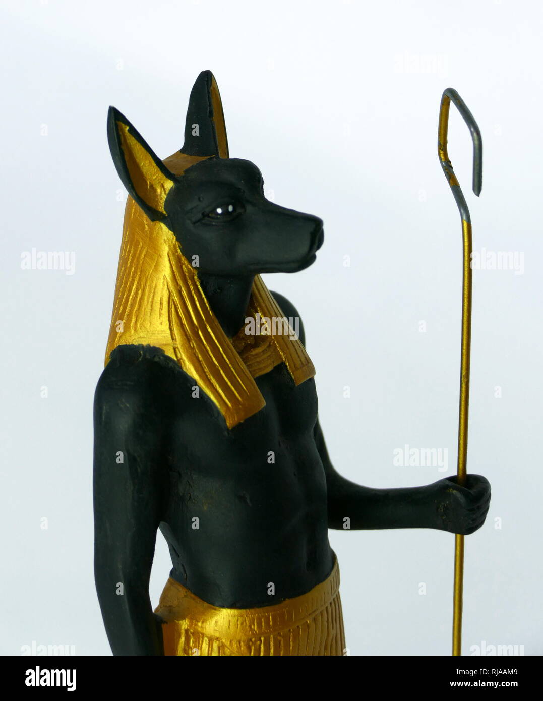 Modern replica statuette of Anubis the god associated with mummification and the afterlife in ancient Egyptian religion. usually depicted as a canine or a man with a canine head. Archaeologists identified the sacred animal of Anubis as an Egyptian canid, that at the time was called the golden jackal, but recent genetic testing has caused the Egyptian animal to be reclassified as the African golden wolf. Stock Photo