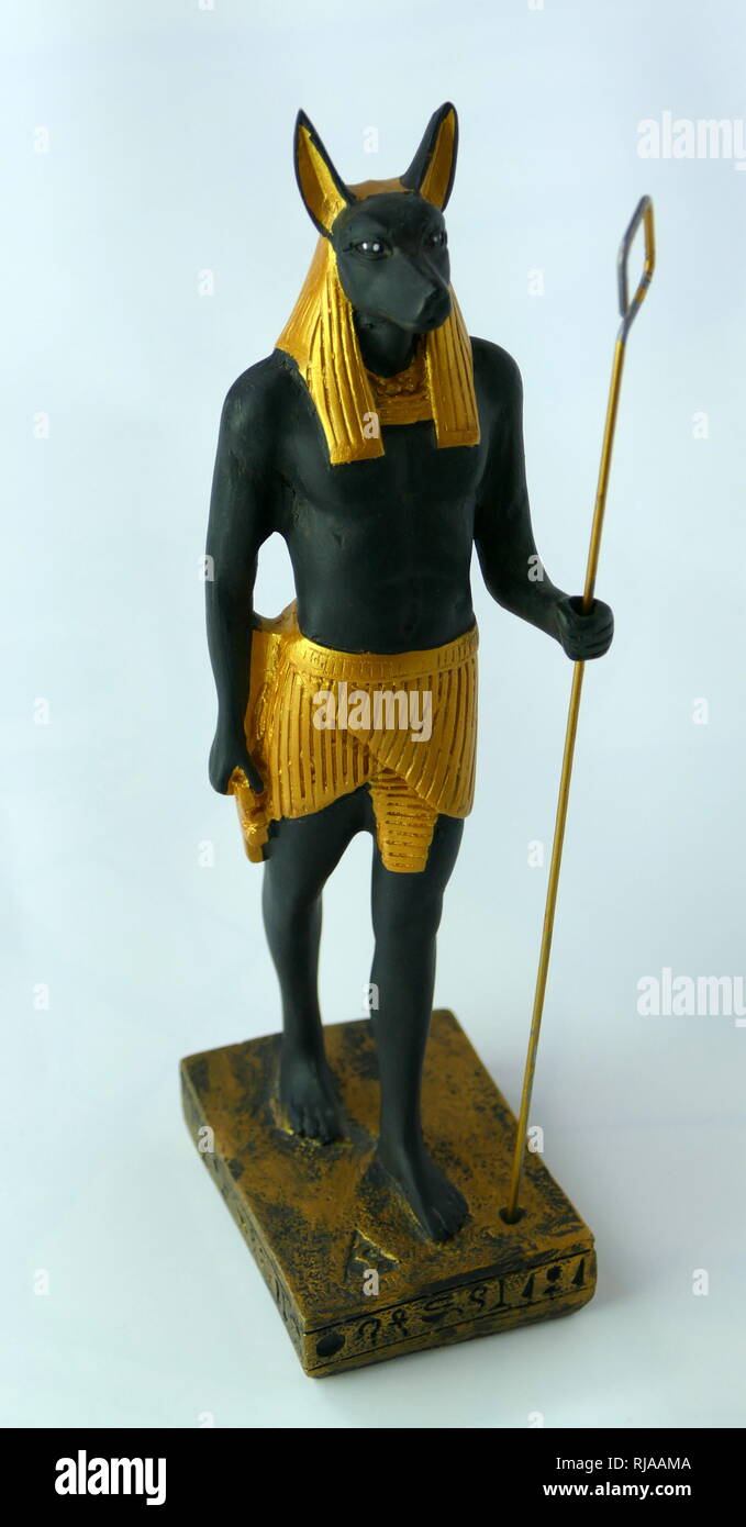 Modern replica statuette of Anubis the god associated with mummification and the afterlife in ancient Egyptian religion. usually depicted as a canine or a man with a canine head. Archaeologists identified the sacred animal of Anubis as an Egyptian canid, that at the time was called the golden jackal, but recent genetic testing has caused the Egyptian animal to be reclassified as the African golden wolf. Stock Photo