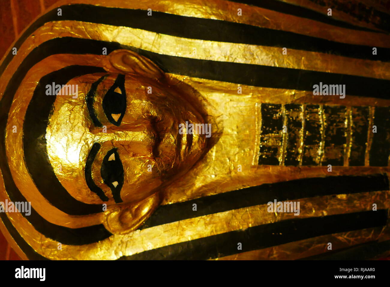 Replica of a gilded ancient Egyptian coffin; 18th dynasty. In 1896 a tomb was discovered in Sheikh Abd el Qurna; by Georges Daressy. The tomb belonged to Hatiay and his wife Henut-Wedjebu. The tomb dates to the time of Amenhotep III and Akhenaten. Henut-Wedjebu was a lady of the house and songstress of Amun. Stock Photo