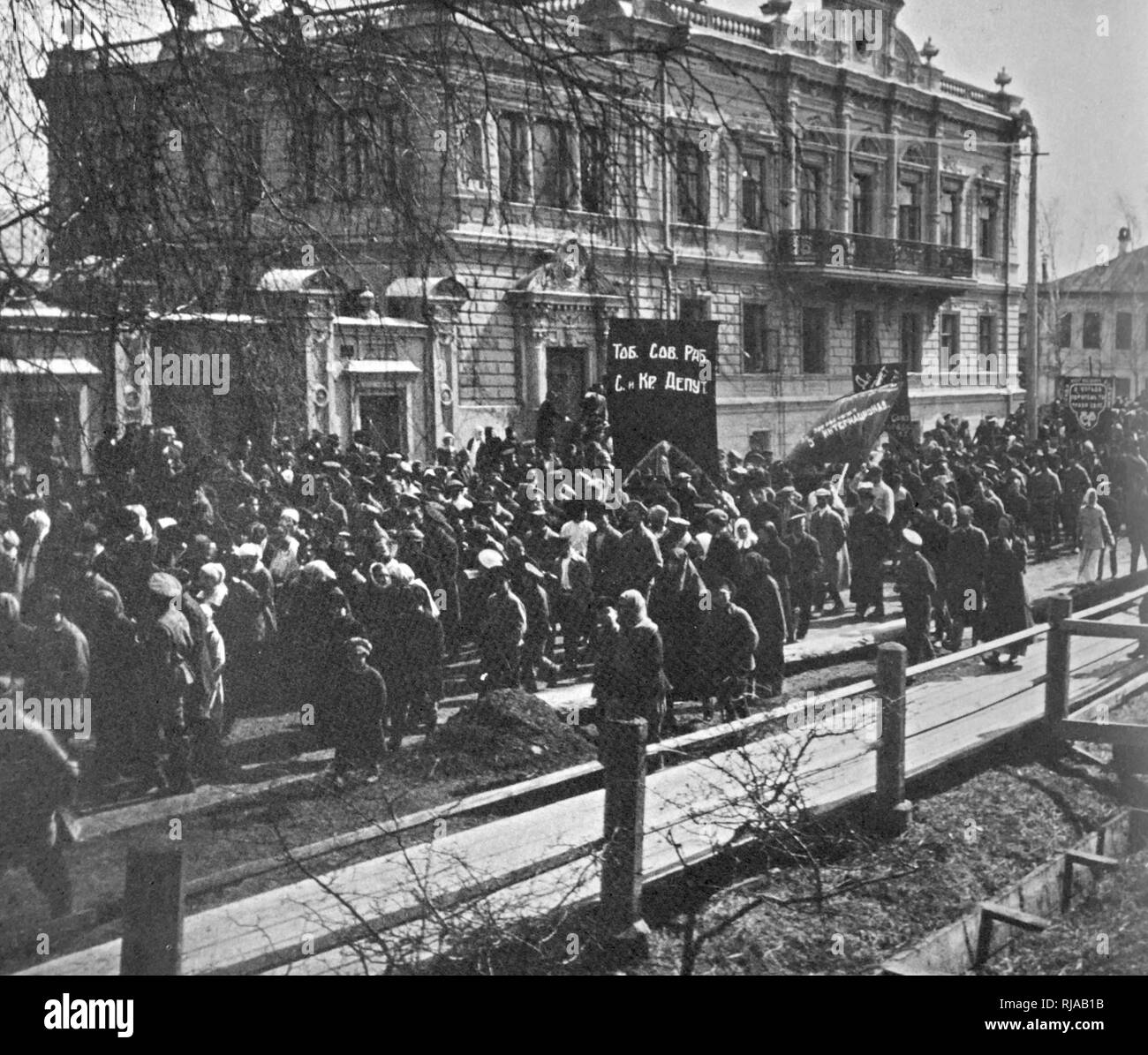 Russian Revolution: Communist march passes the house in Tobolsk, Siberia where the Russian imperial family was imprisoned. The Governor's Mansion, known as Kuklin House was built by merchant Ivan Kuklin in the 1790s. On 12 August 1917, the former Russian Emperor Nicholas II, his wife; five children; and forty-five retainers were imprisoned in the mansion. They remained there until April 1918 Stock Photo