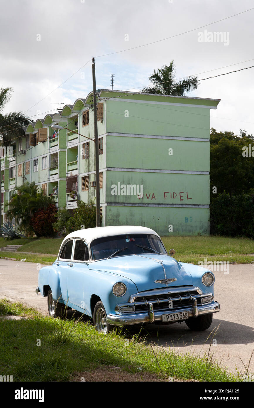 Classic 1950s american car parked on a street outskirts of Havana cuba with Viva Fidel on the wall of a building Stock Photo